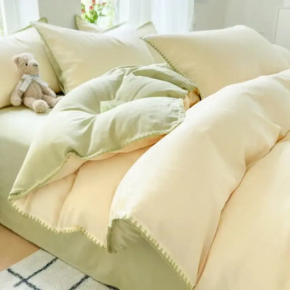 Soft cream cotton bedding set with mint green trim and stitched edge detailing in blush pink and gray cotton bedding