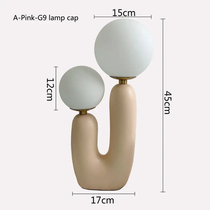 Cream-colored ceramic table lamp with two frosted glass globe shades and gold fittings for decorbites glass ball led lighting