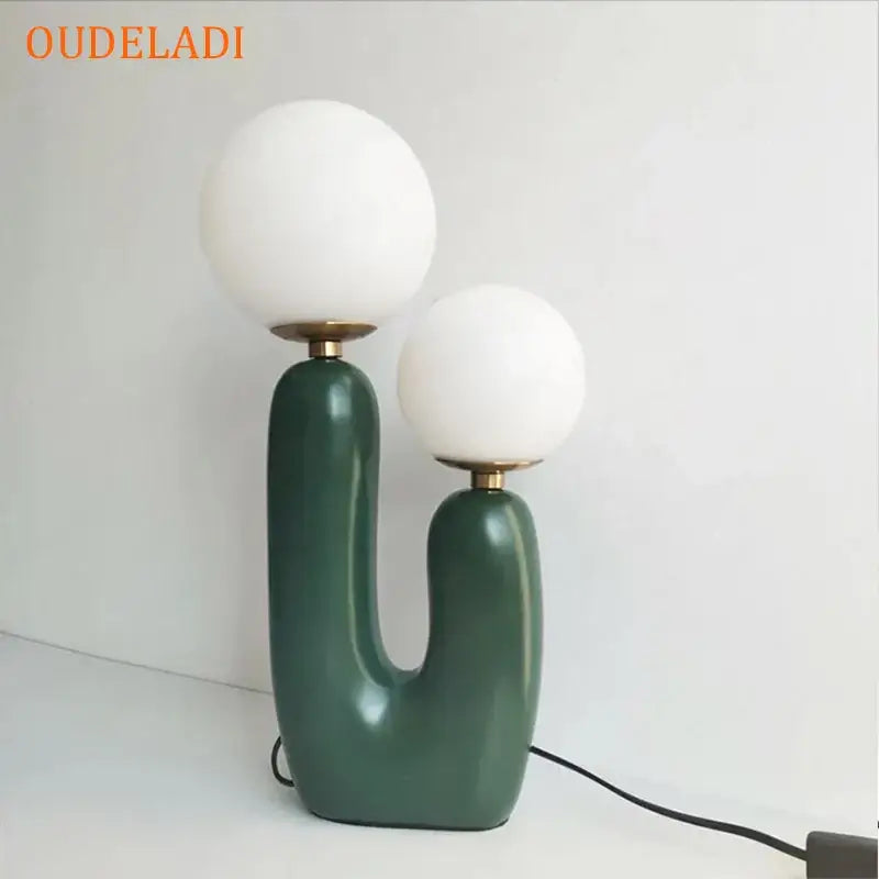Oudeladi table lamp with two white spherical glass ball led shades on a glossy dark green ceramic base for bedroom decorbites