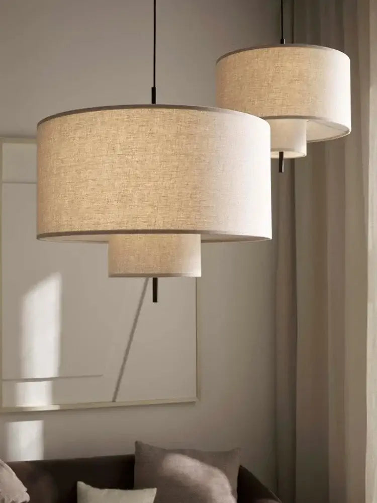 Beige linen tiered pendant lights with textured fabric shades and black cords for dining room decorbites bohemia wabi sabi