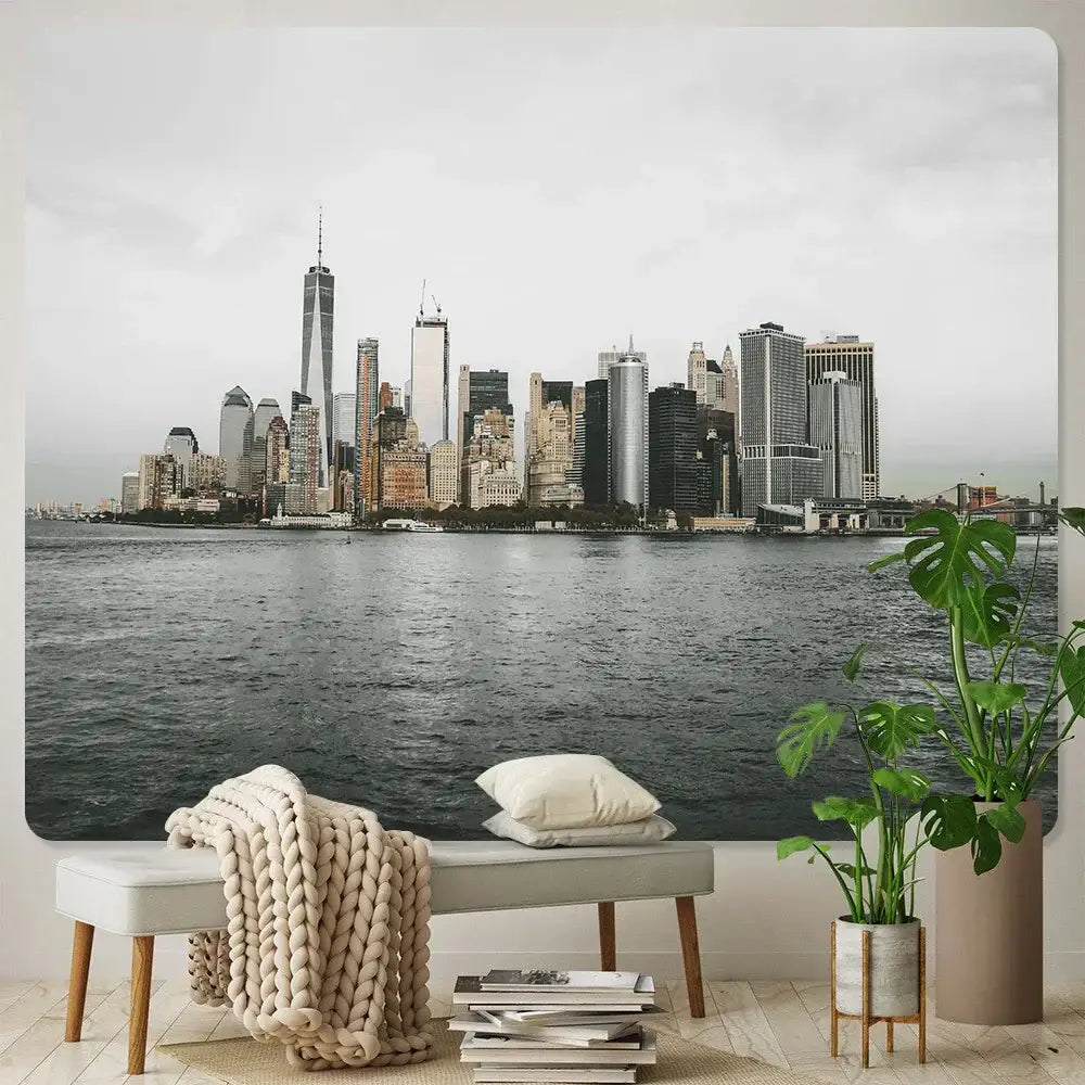 A gray bench with wooden legs draped in a beige knitted blanket and white pillows featuring decorbites bohemian art tapestry