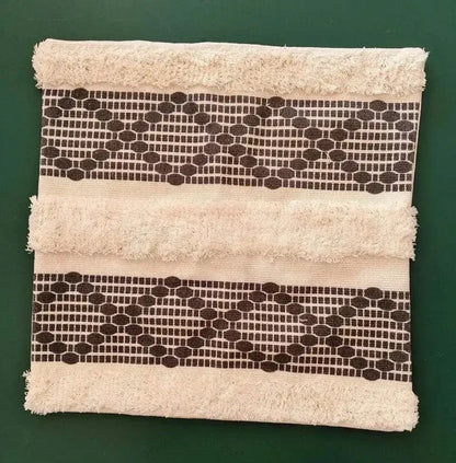 Beige cushion cover with frayed edges and dark brown geometric bands featuring decorbites bohemian tufted tassel design