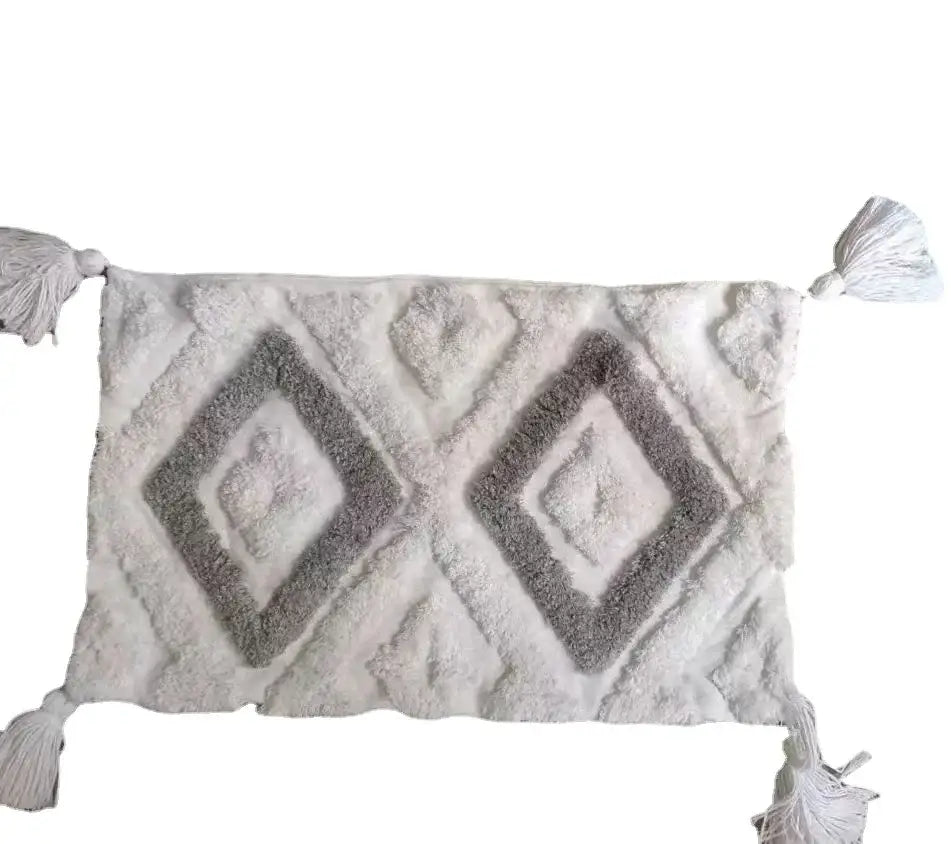 A plush off-white and gray rectangular bath mat with raised diamond pattern and tassels for decorbites bohemian tufted decor