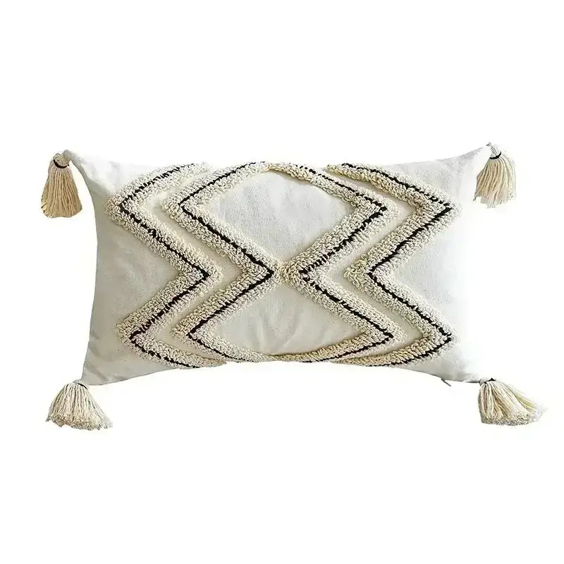 Cream-colored rectangular cushion cover with black and cream geometric embroidery and bohemian tufted tassel decorbites design