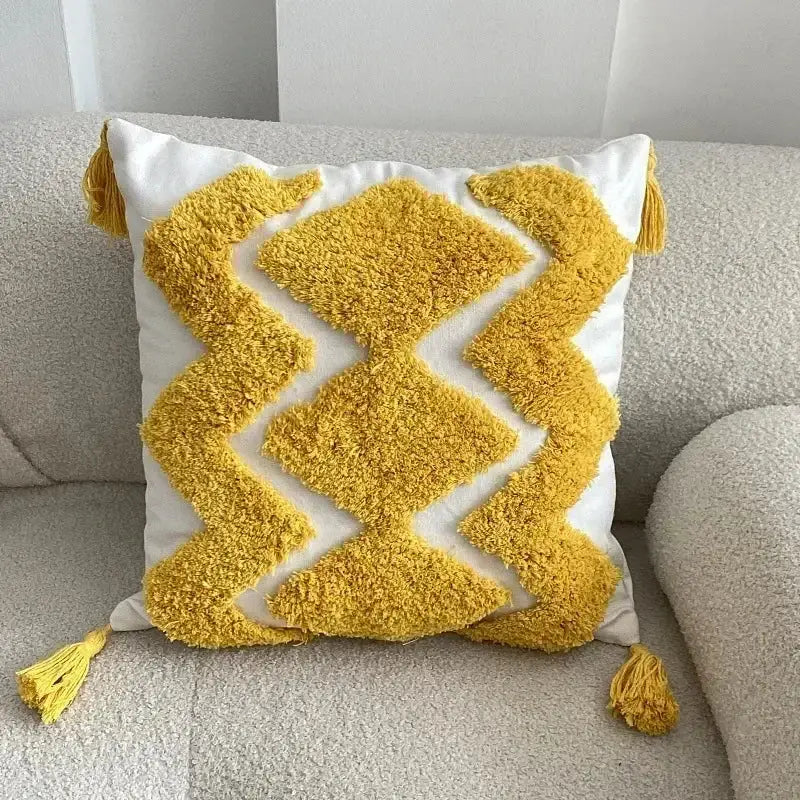 A vibrant yellow and white bohemian tufted cushion cover with geometric pattern and tassels for living room decorbites decor