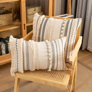 Two rectangular cream cushion covers with gray and black stripes, crochet lace, tassels, and white pom-poms decorbites bohemian beige