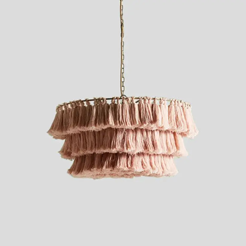Delicate pink tassel light with three cascading tiers of soft fabric on a slender brass suspension light chain by decorbites bohemian chandelier