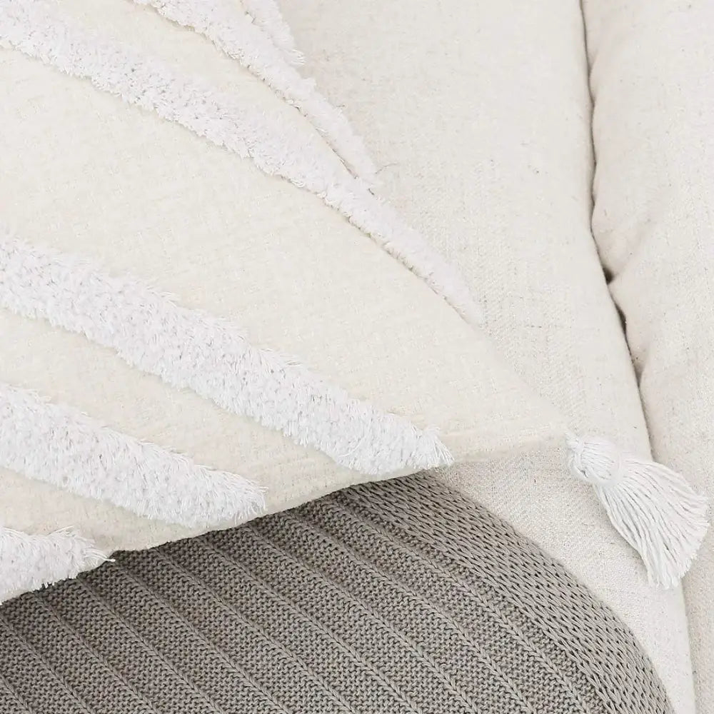 Cream-colored decorbites bohemian chenille pillowcase with textured white fringe stripes and tassel accent for living room
