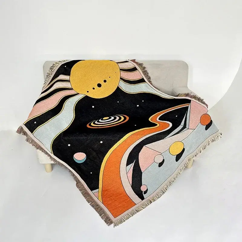 A decorbites bohemian classic woven throw blanket with vibrant cosmic design in pastel pinks on black background