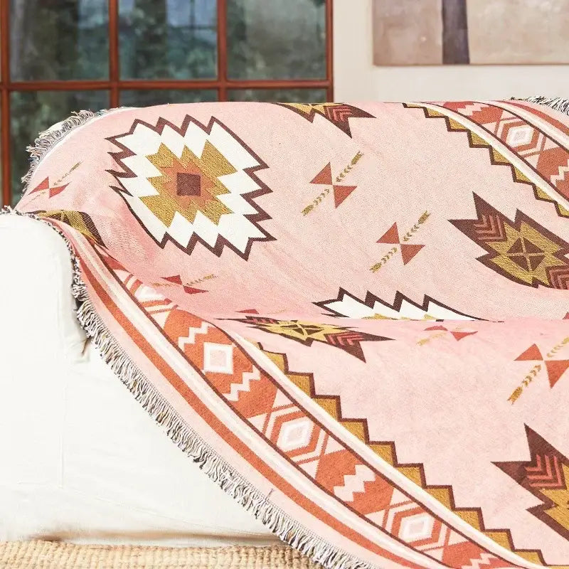 Pink geometric throw blanket with fringed edges and tribal patterns in orange brown and cream bohemian classic design