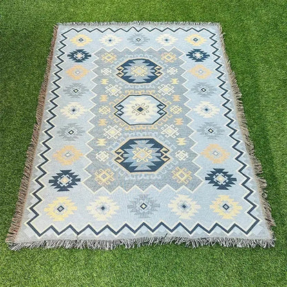 A light blue woven tapestry rug with navy cream and yellow geometric patterns and fringed edges decorbites bohemian classic design