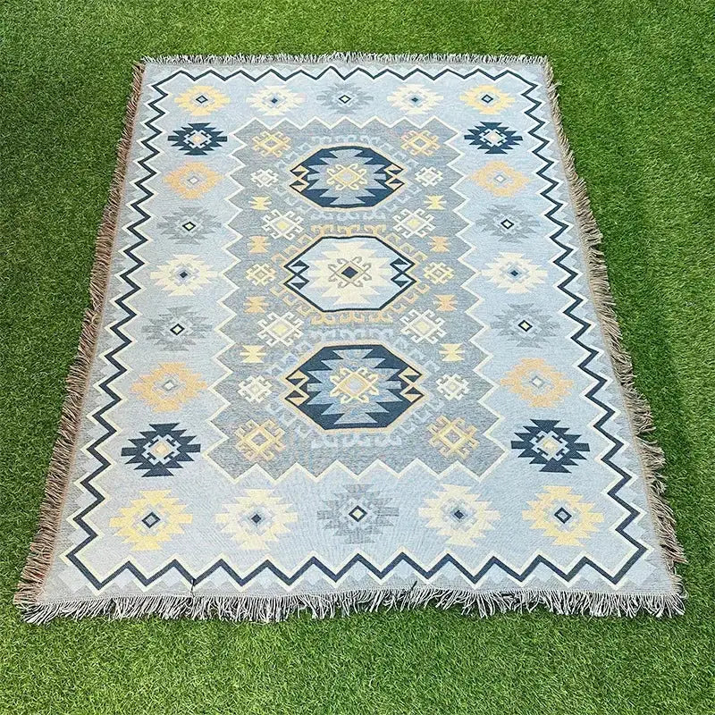 A light blue woven tapestry rug with navy cream and yellow geometric patterns and fringed edges decorbites bohemian classic design