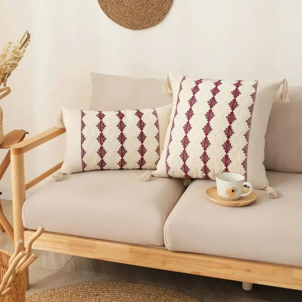 Cream-colored cushion cover with maroon geometric embroidery and tassel trim from decorbites bohemian tassel collection