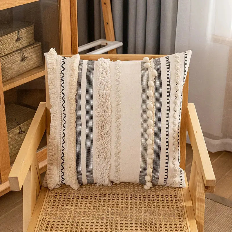 Cozy bohemian cotton cushion cover with cream and gray stripes, textured design, lace trim, and pom-pom accents for living room decor