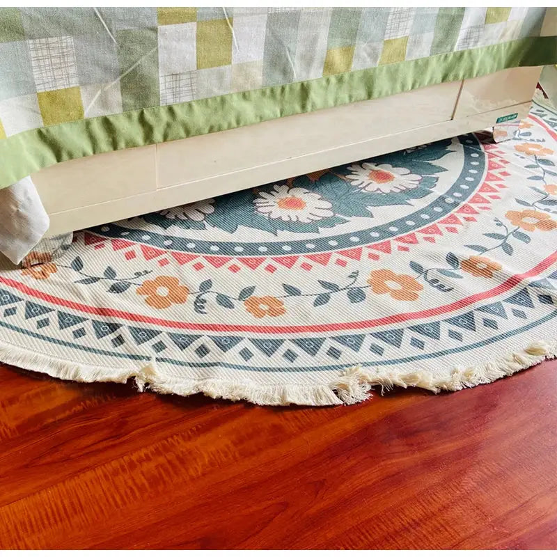 Cream-colored woven bohemian ethnic round area rug with floral geometric patterns in orange teal and red decorbites bohemian ethnic