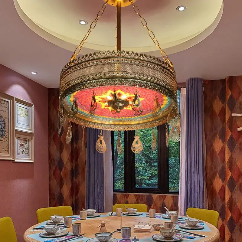 A golden ornate pendant light with mosaic red and yellow center hanging above dining table decorbites bohemian exotic stained