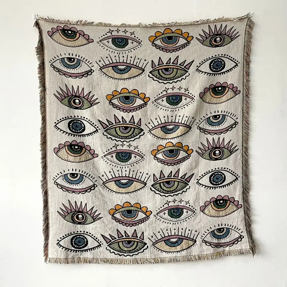 Beige woven bohemian throw blanket with colorful stylized eyes pattern and frayed edges for living room decorbites throw blanket