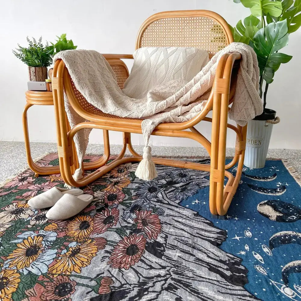 Woven rattan armchair with curved back draped in cream decorbites bohemian throw blanket with fringed tapestry design