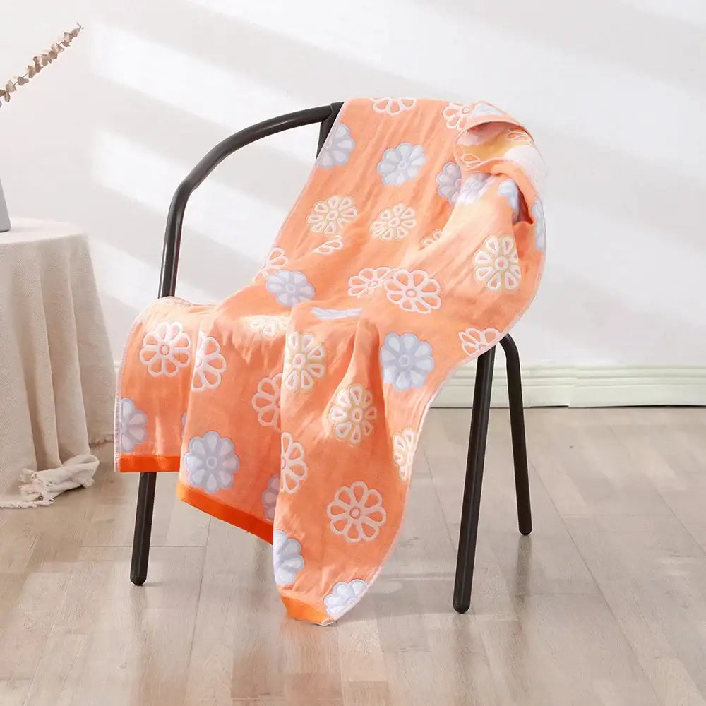Orange bath towel with white and gray blossoms draped on black chair bohemian floral cotton decorbites wrap