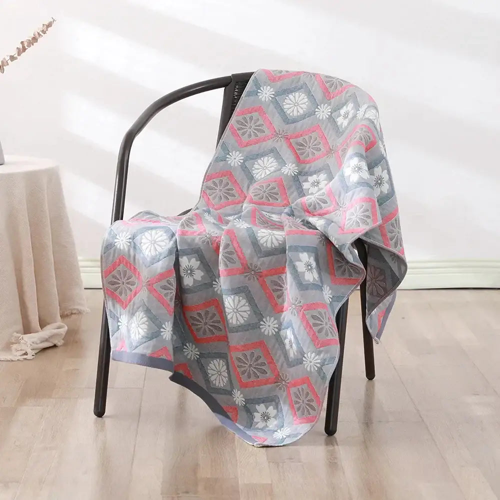 A soft, lightweight bohemian floral cotton bath towel with pink and gray geometric squares for bathroom wrap use