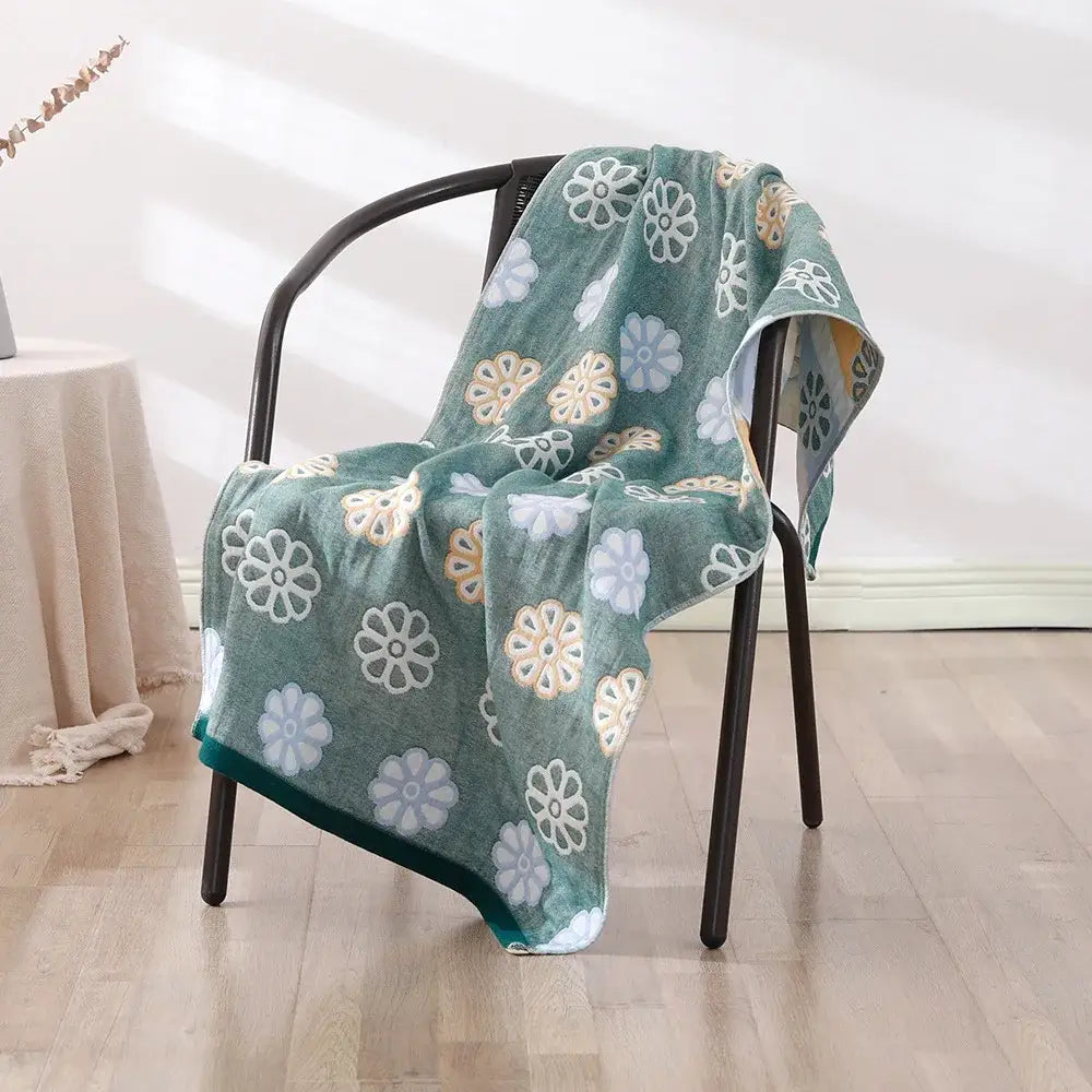 A soft teal bohemian floral cotton bath towel with plush texture and embroidered white and beige floral decorbites design