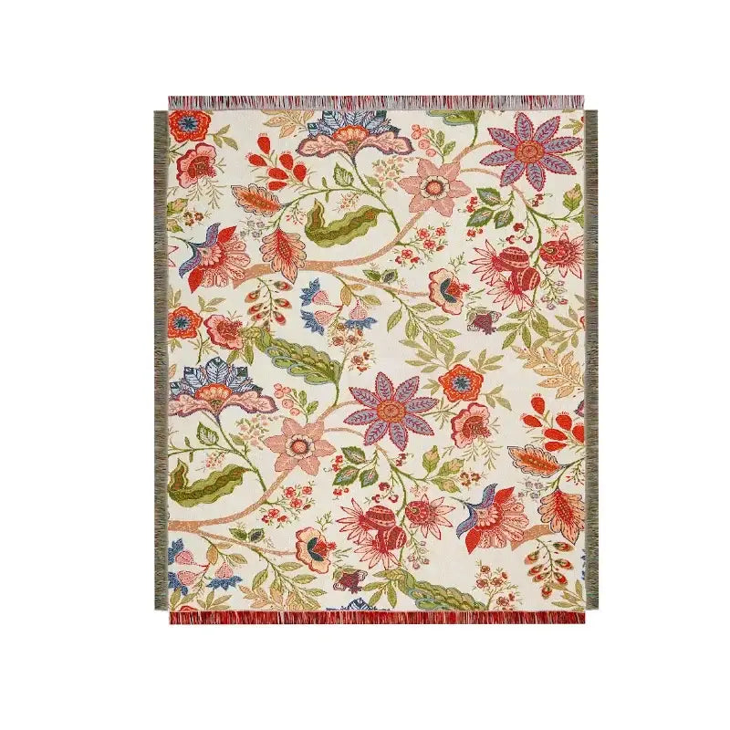 A cream-colored woven bohemian floral leisure blanket with vibrant red pink purple blue blossoms and green leaves decorbites bohemian floral