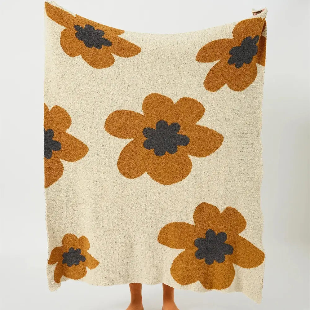 Cream-colored decorbites bohemian flower knitted throw blanket with plush oversized orange flowers and dark gray centers
