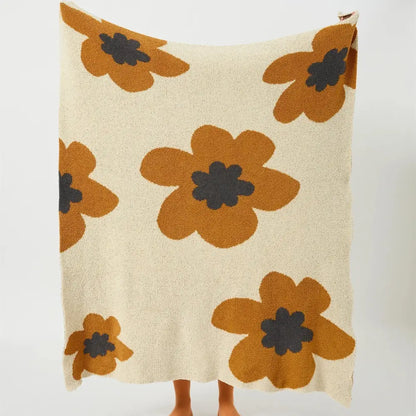 Cream-colored decorbites bohemian flower knitted throw blanket with plush oversized orange flowers and dark gray centers