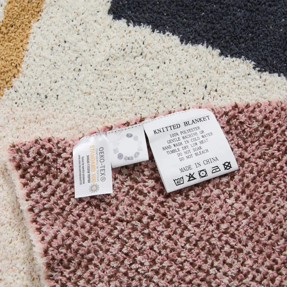 A soft pink bohemian flower knitted throw blanket with chunky texture and woven care labels for decorbites bohemian flower decor