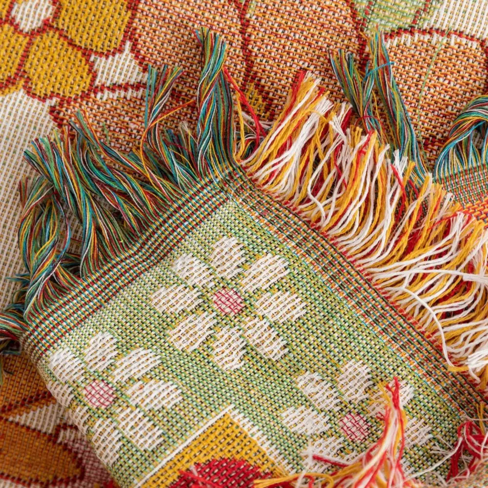 Bohemian flowers woven sofa blanket with white and pink floral pattern on green background and fringed edges