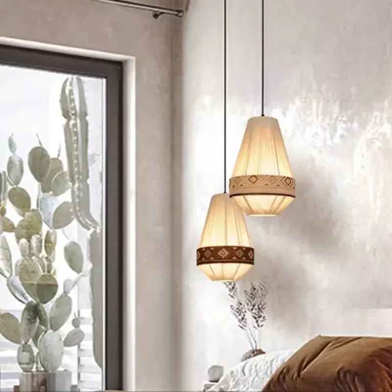 Two warm-toned bohemian fringe pendant lamps with woven paper shades and brown geometric bands for dining room