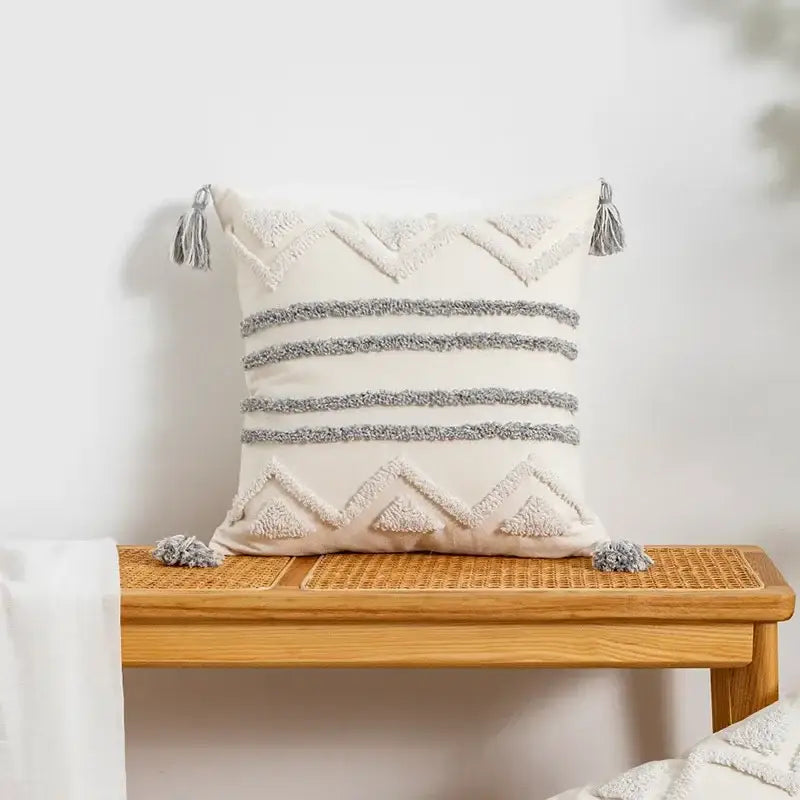 Cream-colored cushion cover with textured gray geometric patterns and tassels for bohemian decorbites geometric tufted style
