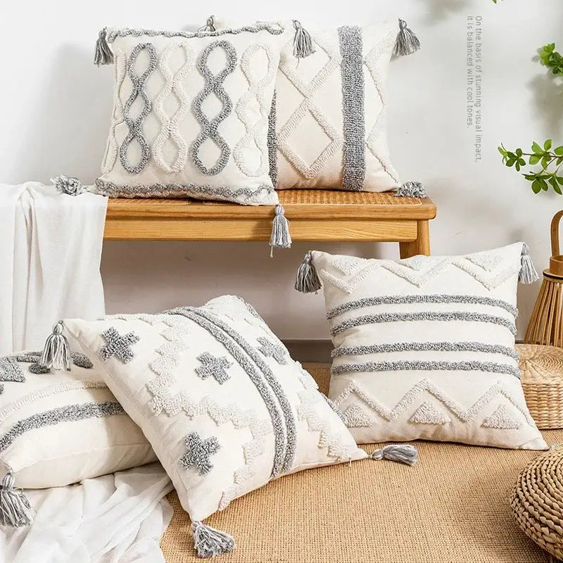Cream-colored cushion cover with textured gray geometric embroidery and tassels for decorbites geometric tufted decor