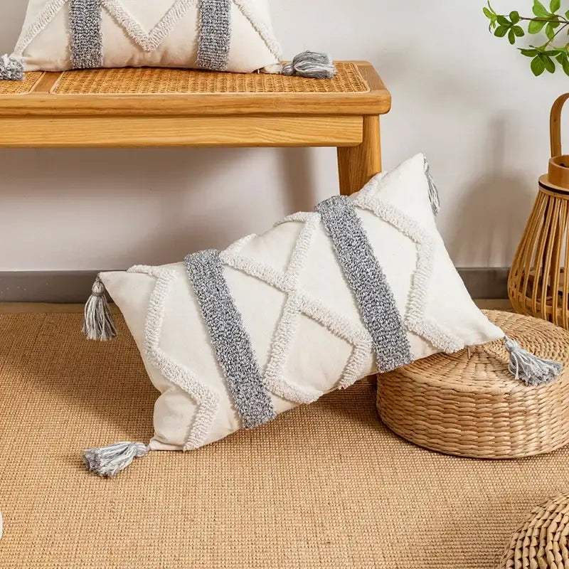 Cream-colored cushion cover with textured gray woven stripes and tassels for decorbites geometric tufted decor