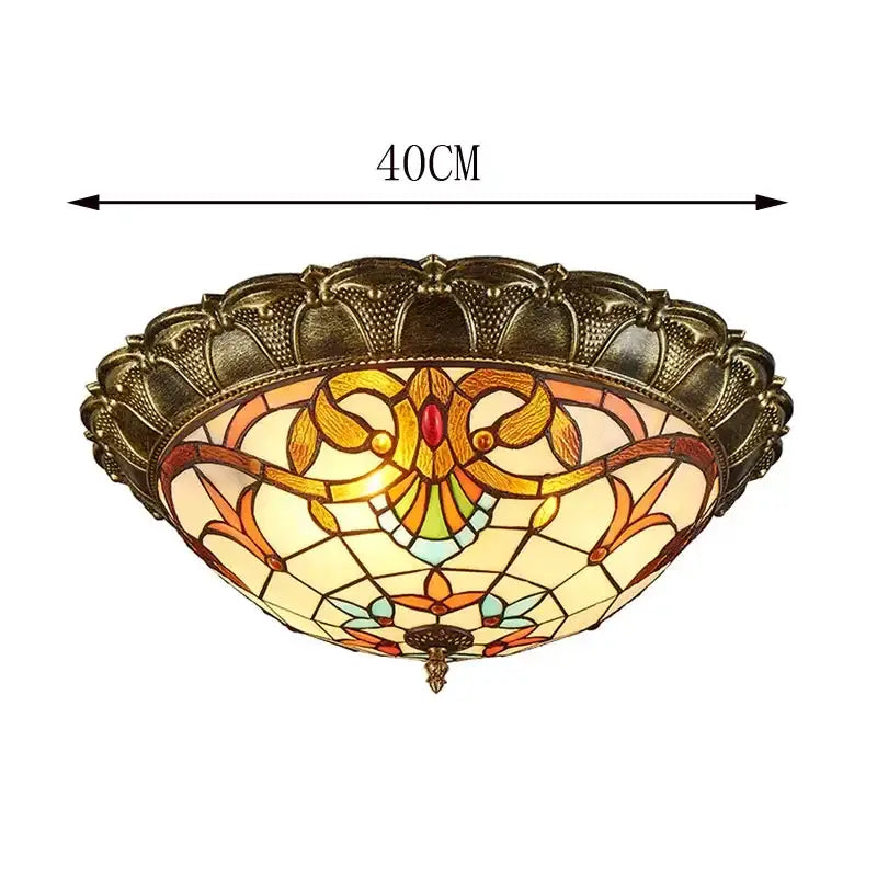 Antique brass-finished bohemian glass ceiling light with amber stained glass and intricate floral patterns by decorbites