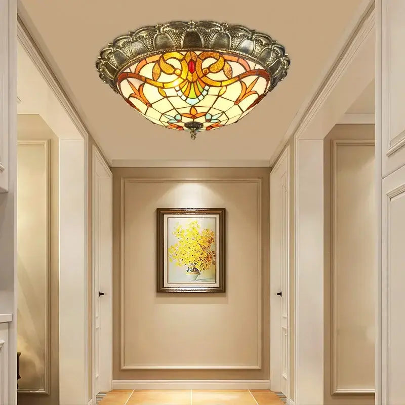 Bohemian glass ceiling light with amber stained glass and ornate silver frame featuring floral patterns by decorbites