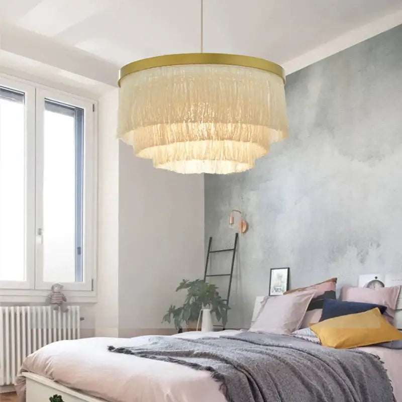 A cream-colored fringe bohemian gold tiered chandelier with a gold-toned frame for bedroom decorbites bohemian gold light