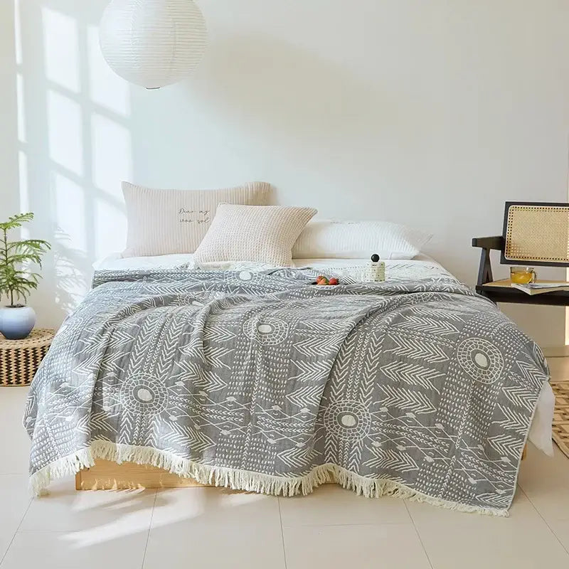 Gray throw blanket with white geometric patterns and fringed edge made of decorbites bohemian cotton for bedroom use
