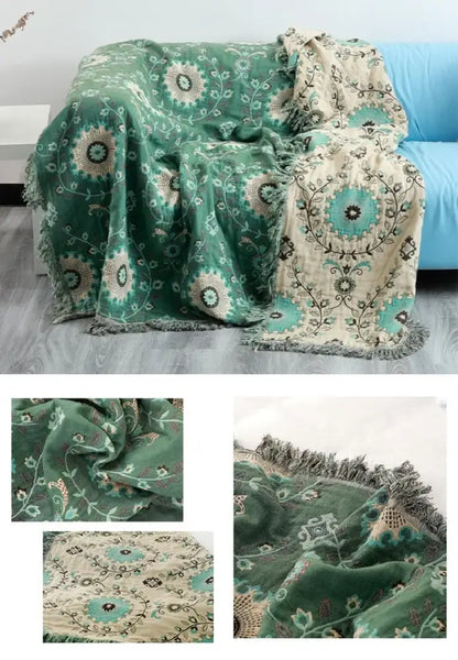 A plush green and cream decorbites bohemian cotton throw blanket with teal floral embroidery and fringed edges for sofa or bed