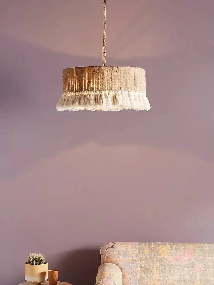 Bohemian hemp rope pendant light with textured gold-toned metal frame and white tassels for dining room decorbites