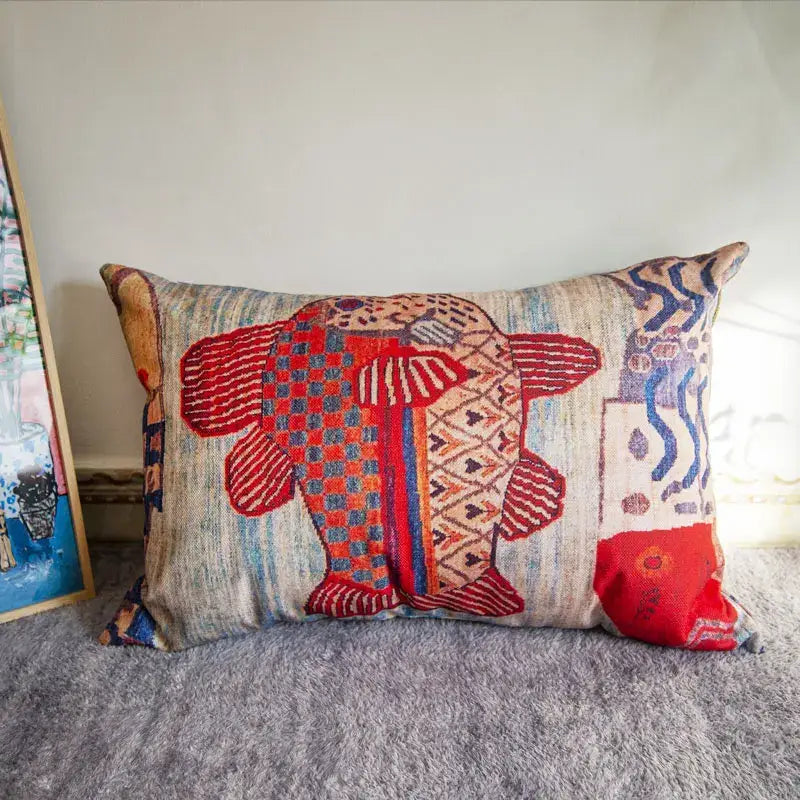 Rectangular bohemian jute linen pillow cover with vibrant embroidered fish in reds blues on textured fabric background