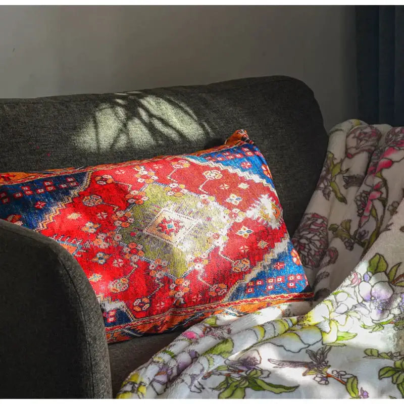 Vibrant red and blue bohemian jute linen pillow covers with geometric and floral designs on dark gray sofa decorbites bohemian jute