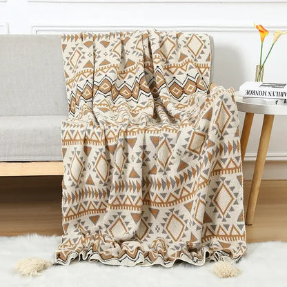 A cozy cream and tan geometric decorbites bohemian knitted sofa blanket with tassels for beige and brown bedroom decor