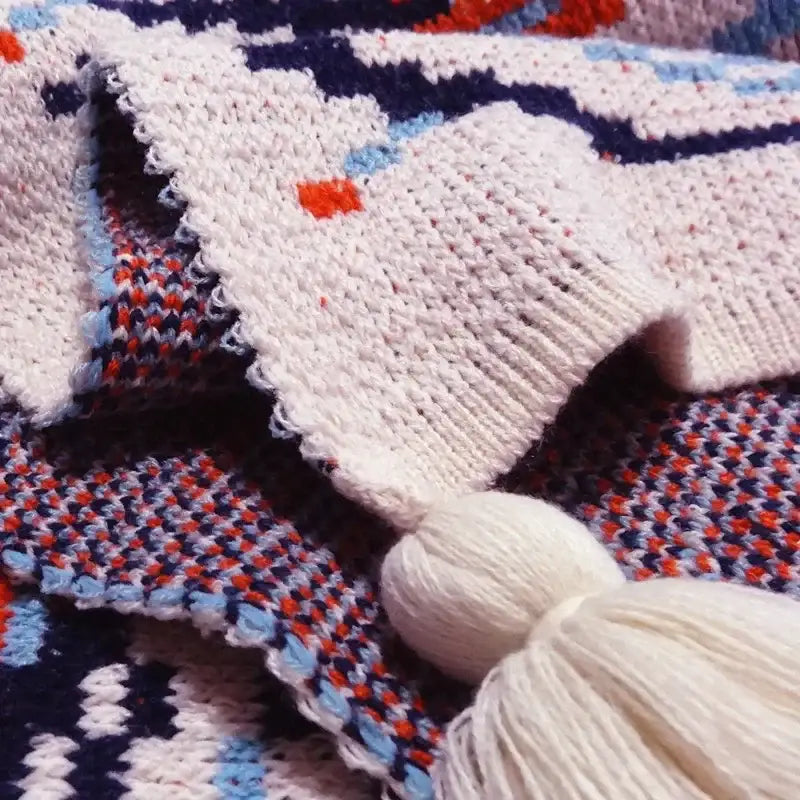 Cream-colored decorbites bohemian knitted sofa blanket with navy blue geometric pattern and white tassel for bedroom decor