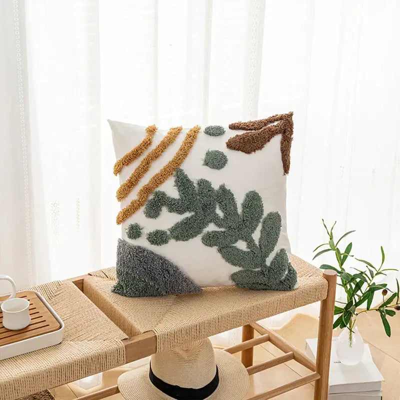 White plush cushion cover with textured abstract botanical design in green brown and gold bohemian loop style