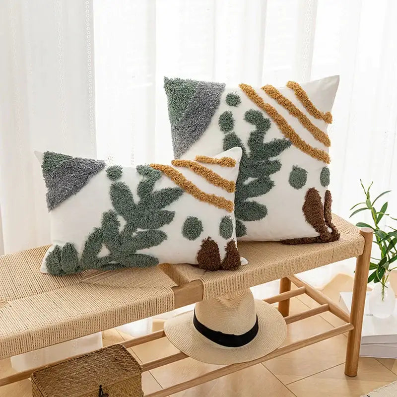 Two white bohemian loop plush cushion covers with textured tufted botanical patterns in green brown and gray
