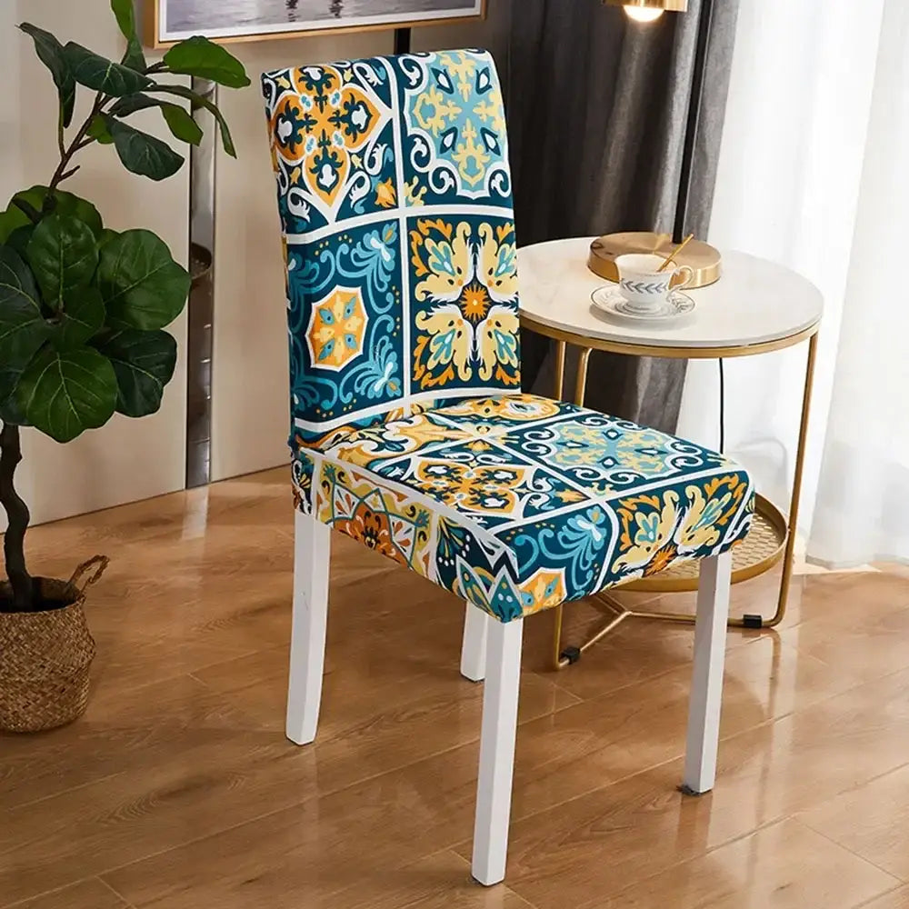 A vibrant bohemian mandala stretch chair cover in teal yellow and white featuring a bold mosaic tile pattern