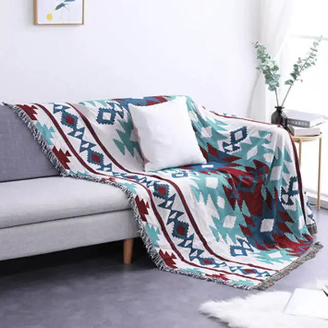 Cozy bohemian multicolored geometric tassel sofa cover with teal red and white pattern and fringed edges by decorbites