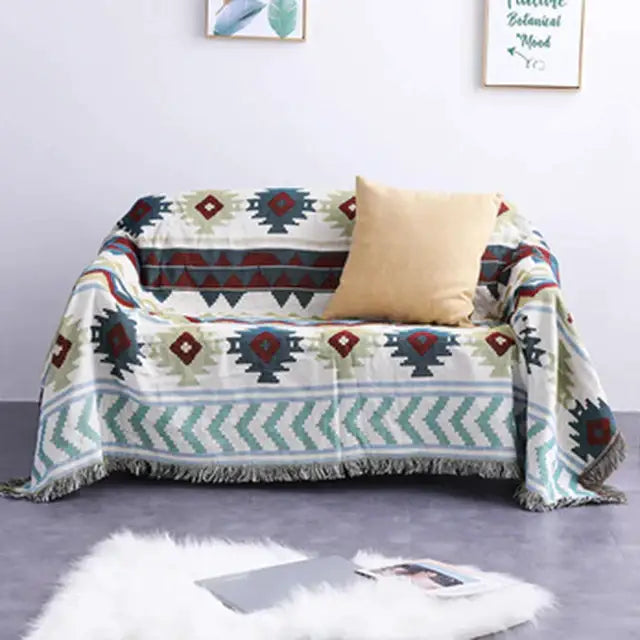 A cozy cream-colored woven sofa cover with decorbites geometric tassel pattern and fringed edges for living room decor