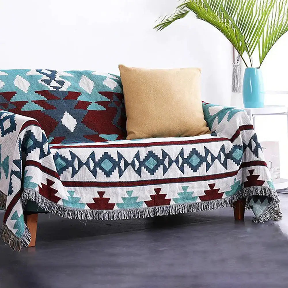 Bohemian multicolored geometric tassel sofa cover with a cozy tribal pattern in teal maroon navy blue and white decorbites geometric tassel